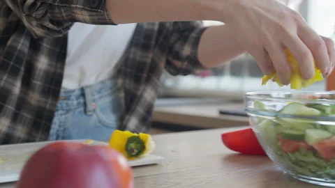Adding Sliced Pepper Into Bowl With Fresh Salad, Close-Up Hand In Bright Kitchen Stock Footage 308455527