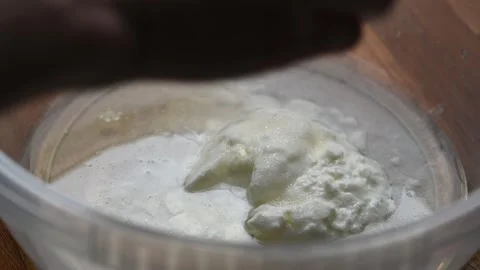 Adding some bread making ingredients in a large plastic bowl. Stock Footage 243858750
