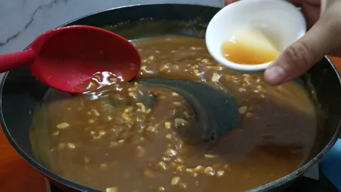 Adding Some Sesame Oil in a Thick Brown Sauce Stock Footage 234882701