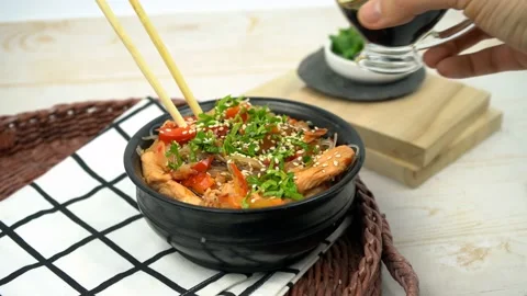 Adding soy sauce. Asian salad with rice noodles, vegetables, mushrooms Stock Footage 152920531