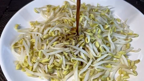 Adding soy sauce to bean sprouts Stock Footage 173098668