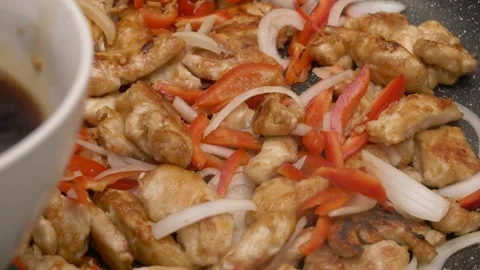 Adding soy sauce to a chicken and vegetables stir fry 库存影片 290090191