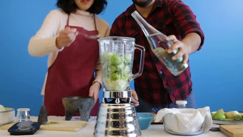 Adding spices and water to a fresh batch of Mexican green salsa Video stock 124664663