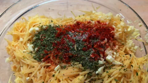 Adding spices to a bowl of grated potatoes. Cooking hash browns at home. POV Stock-Footage 260272359