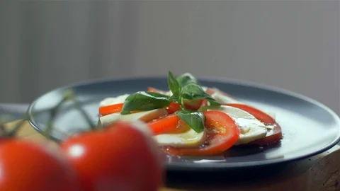 Adding spices to the Caprese salad. Black background 動画素材 109269364