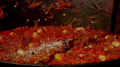 Adding Spices to Traditional Romanian Zacusca in a Cauldron over Wood Fire Video stock 288689224