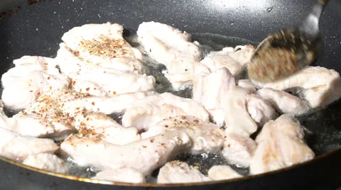 Adding spices to turkey meat on a pan Stock Footage 60056980