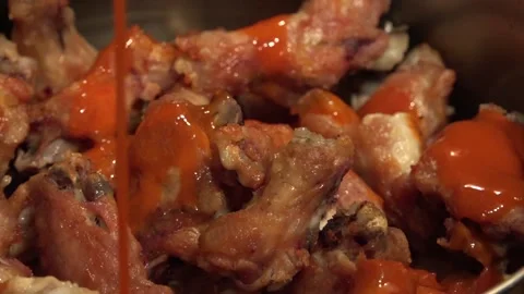 Adding a spicy sauce over Chicken Wings Stock Footage 239639192