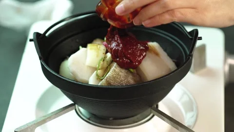 Adding Spicy Sauce into Pot Filled with Cooking Ingredients 動画素材 335732804