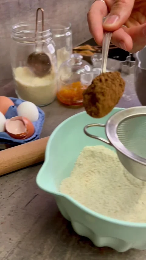 Adding a spoon of chocolate powder to the ingredient mix Stock Footage 303823161