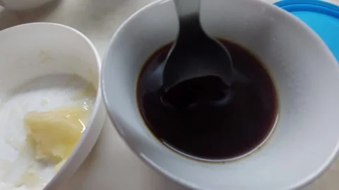 Adding a spoonful of natural honey into a cup of black coffee Stock Footage 333644173