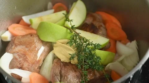 Adding sprigs rosemary to the braised pork shoulder in a pot. Stock Footage 244387087