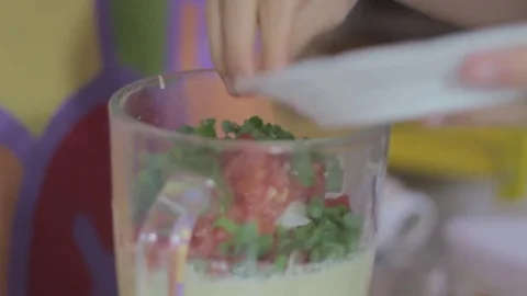 Adding spring onions to a blender full of beautiful stuff Stock Footage 79537188