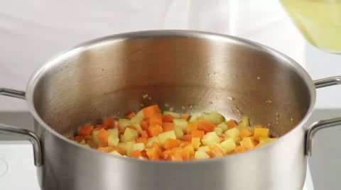 Adding stock to sweated chopped vegetables Stock Footage 24662201