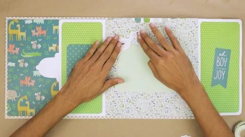 Adding stork sticker to baby themed scrapbook album layout to decorate Stock Footage 281005908
