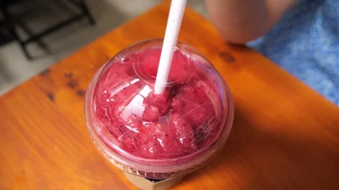 Adding a straw to a pink smoothie in a cafe Stock-Footage 277514154