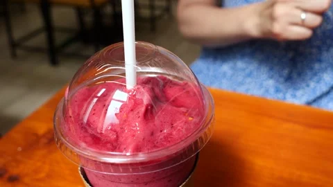 Adding a straw to a pink smoothie in a cafe Stock-Footage 277514524