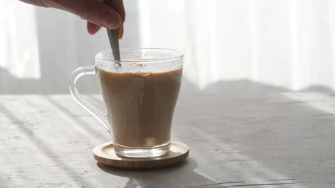 Adding sugar to coffee cup, spoon is stirring sugar in a mug, morning light Stock Footage 176870574