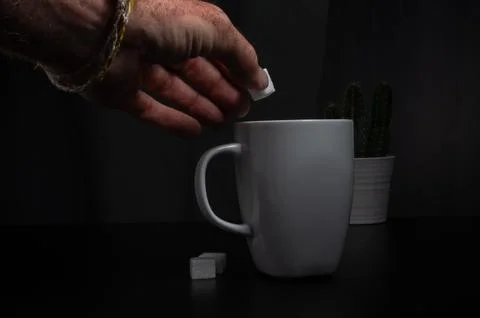 Adding Sugar to Coffee in a Minimalist Setting Stock Photos