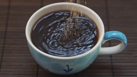 Adding sugar into the coffee in slowmotion Stock Footage