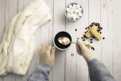 Adding a sugar cube into coffee. Stock Photos
