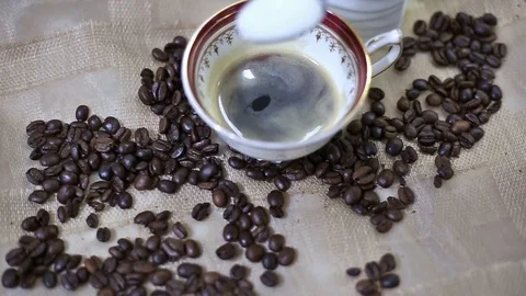 Adding sugar into a cup of fresh espresso coffee Video stock 108090564