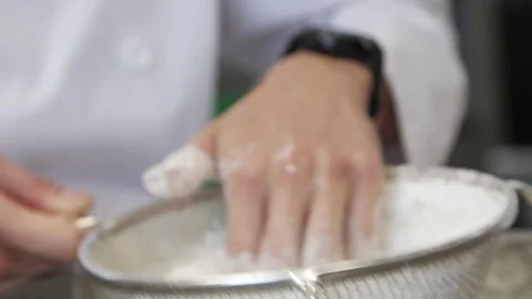 Adding sugar to the donuts Stock Footage 307339932