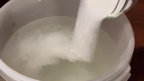 Adding Sugar to Fermentation Mash for Moonshine. Stock Footage 301345690