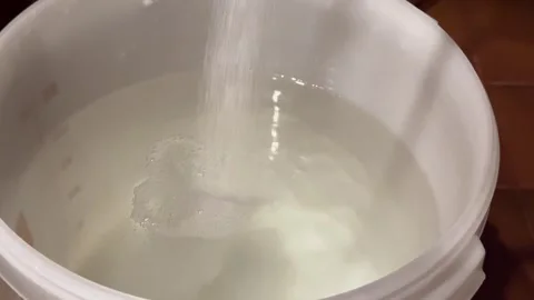 Adding Sugar to Fermentation Mash for Moonshine. Stock Footage 301345911