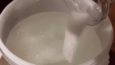 Adding Sugar to Fermentation Mash for Moonshine. Stock Footage 301345912