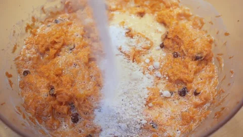 Adding sugar to grated carrots and raisins Stock Footage 107755206