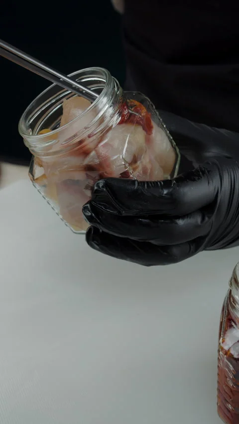 Adding sun-dried tomatoes to jar with smoked fish Video stock 308353764