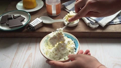 Adding sweetener to cottage cheese or mascarpone in a bowl to make a healthy des Stock Footage 131673128