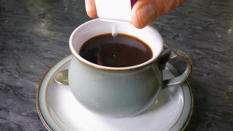 Adding sweeteners to a cup of black coffee. Stock Footage 120635693