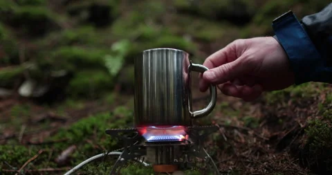 Adding tea leaves to a metal pot that is heated on a gas burner Stock Footage 244141008