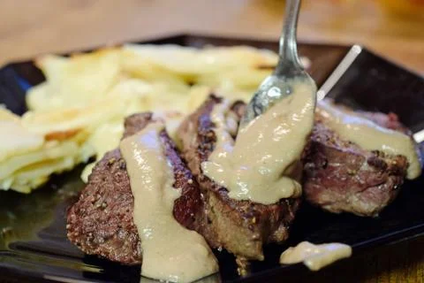Adding thick peppercorn sauce for steaks Stock Photos