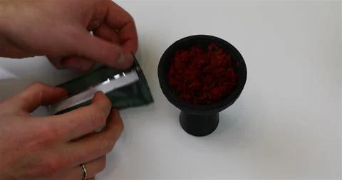 Adding tobacco to a hookah silicone cup Stock Footage 102400580