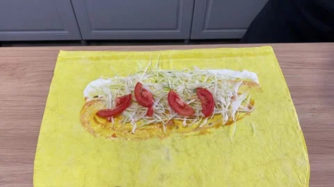 Adding tomato and cucumber to shawarma on flatbread Stock Footage 318912180