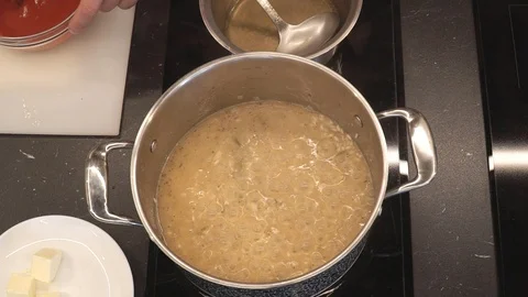 Adding tomato mash to rice overhead Stock Footage 112127659