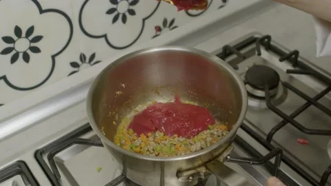 Adding tomato paste into hot cooking pot with vegetables. Slow motion. Stock-Footage 154225232