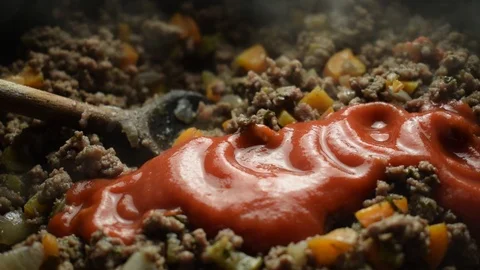 Adding tomato puree to minced meat Stock Footage 122611101