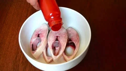 Adding tomato sauce into the fish For marination Stock Footage 152528683
