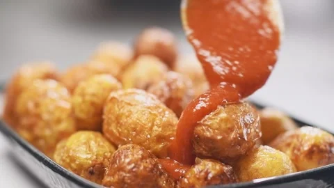 Adding tomato sauce on fried small new potatoes. Vídeos de archivo 153481134
