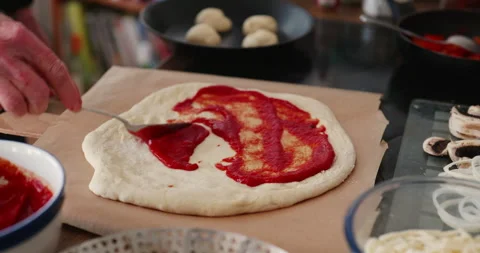 Adding tomato sauce to pizza Stock Footage 241607020