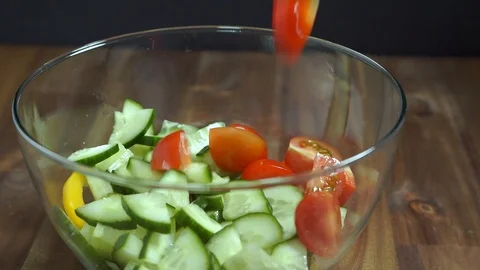 Adding tomatoes to salad. Vegetable salad. Stock Footage 124076673
