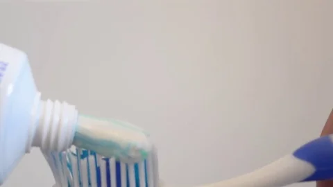 Adding toothpaste on toothbrush Stock Footage 76998970