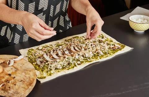 Adding toppings to pesto flatbread Stock Photos