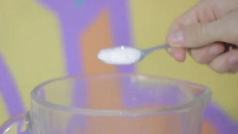Adding a tsp of salt to a blender on a yellow and orange background Stock Footage 79536540