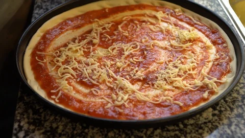 Adding tuna to a fresh pizza before baking Stock Footage 117416016