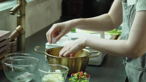 Adding Various Ingredients into Cooking Pot in Kitchen Stock Footage 335732807